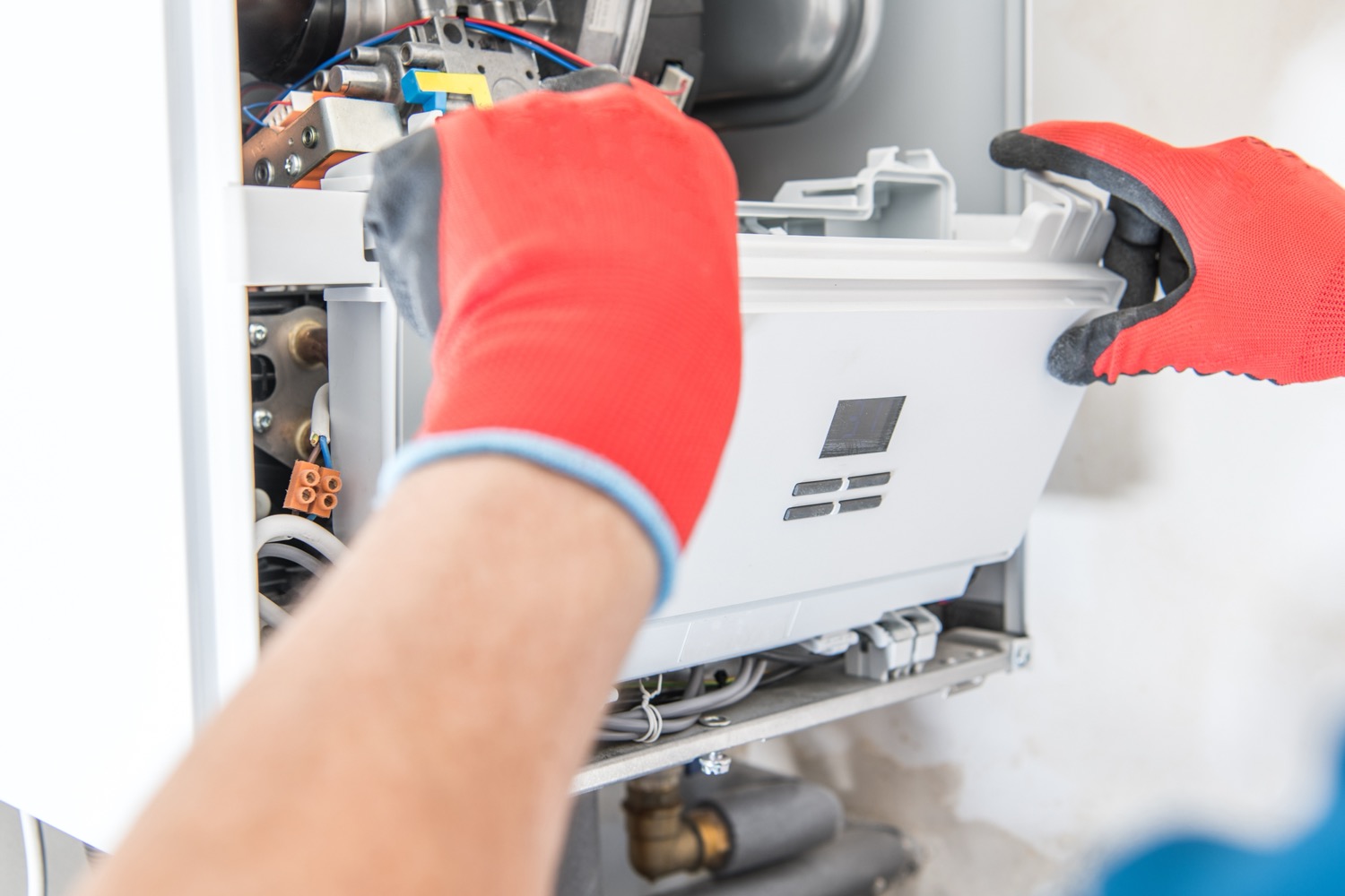 Technician inspecting an aging HVAC system in a Fresno home to determine if replacement is needed